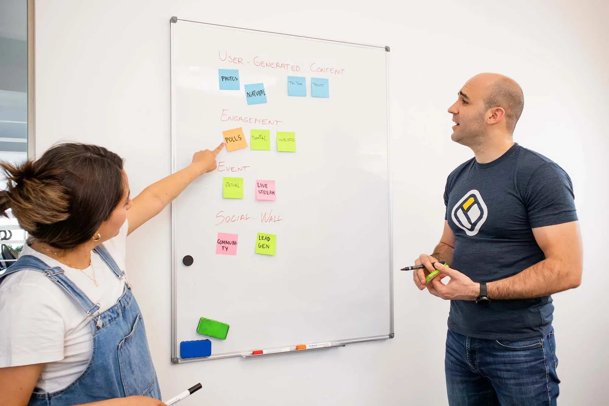 Two people planning social media content ideas on a whiteboard