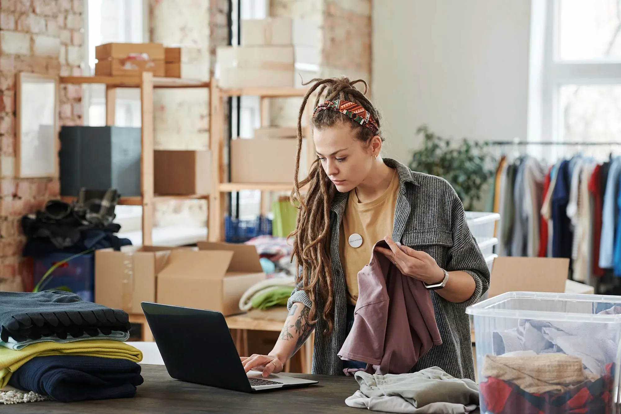Small business owner managing products and social media marketing on a laptop